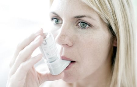 Mujer utilizando un inhalador.