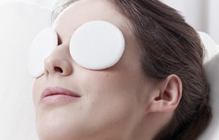 Mujer relajándose con parches fríos en los ojos