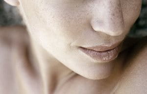 Parte inferior de la cara de una mujer con pecas.