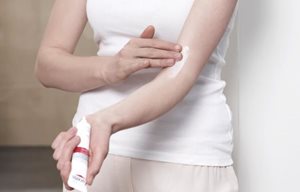 Mujer aplicándose Eucerin AtopiControl Crema Forte en la cara interna del brazo.